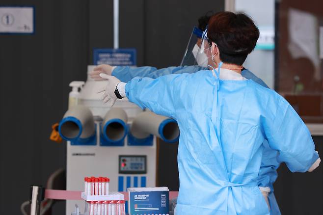 19일 오전 서울역 중구 신종 코로나바이러스 감염증(코로나19) 임시선별검사소에서 검사소 관계자들이 시민들을 안내하고 있다. [연합]