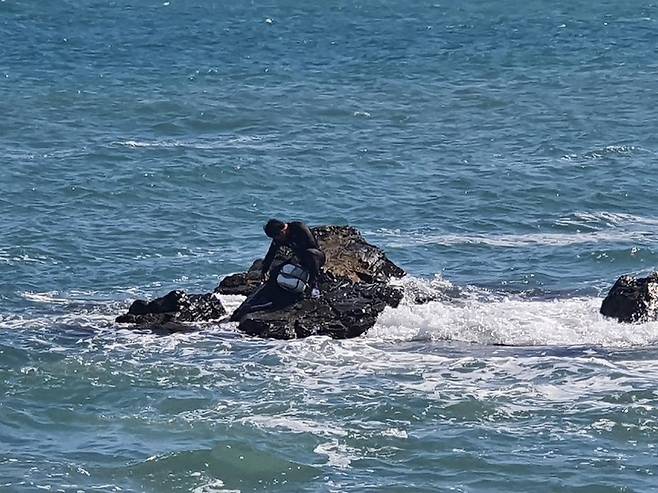 [울산=뉴시스]바다에 들어가 조개를 잡다 파도에 휩쓸리면서 갯바위 위에 고립된 30대 남성. (사진=울산해양경찰서 제공) photo@newsis.com *재판매 및 DB 금지
