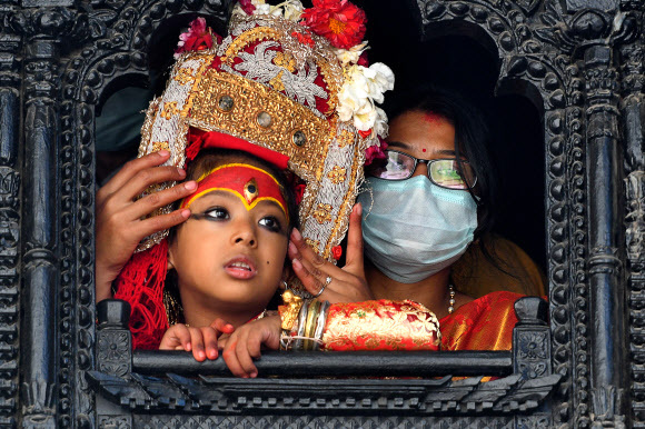 지난 19일(현지시간) 네팔 카트만두 바산타푸르 광장에서 힌두교인들의 축제인 인드라 자트라(Indra Jatra·옌야)가 열린 가운데, 살아 있는 신 ‘쿠마리’가 행차를 위해 대기하고 있다. 카트만두=AFP연합