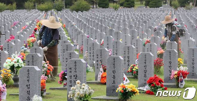 (대전=뉴스1) 김기태 기자 = 2일 오후 대전 유성구 국립대전현충원 장병 1묘역에서 작업자들이 벌초를 하고 있다. 2021.9.2/뉴스1