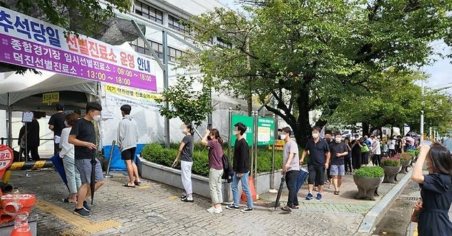 한가위 당일인 21일 전북 전주시 덕진 선별진료소를 찾은 시민들이 신종 코로나바이러스 감염증(코로나19) 진단 검사를 받기 위해 줄을 서 기다리고 있다. 전주=뉴스1