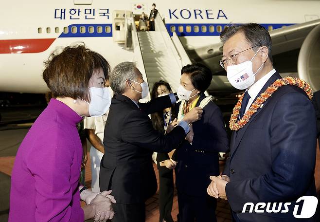 한미 유해 상호 인수를 위해 미국 하와이를 방문한 문재인 대통령과 김정숙 여사가 21일(현지시각) 히캄 공군기지에서 데이비드 이게 하와이 주지사 내외로부터 전통 화환을 받고 있다. (청와대 페이스북) 2021.9.22/뉴스1