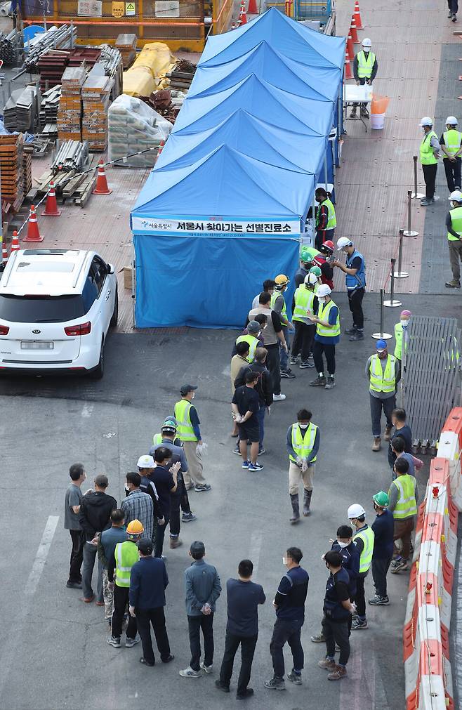 추석 연휴가 끝나자마자 코로나19 신규 확진자 수가 크게 늘면서 최다치를 기록한 24일 오전 서울역 광장 인근 공사장에 마련된 서울시 찾아가는 선별진료소에서 공사장 관계자들이 검사를 받기 위해 기다리고 있다. 중앙방역대책본부(방대본)는 이날 0시 기준으로 신규 확진자가 2434명 늘어 누적 29만5132명이라고 밝혔다. 지난달 11일 2221명 이후 44일 만에 최다 기록을 경신했다. 연합뉴스