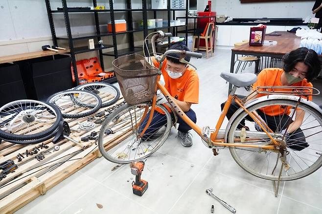 지난 23일 광주시 광산구 앰코로 35 ‘폭스존’ 건물 1층에 문을 연 ‘방치자전거 재사용센터’에서 청년들이 자전거를 해체해 수리하고 있다.