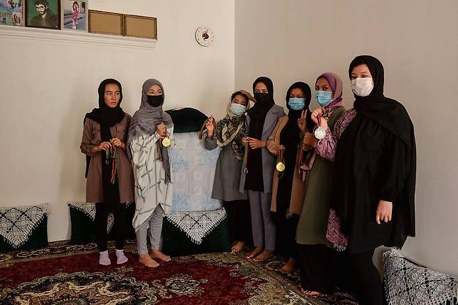 지난 21일(현지시간) 아프가니스탄 헤라트주의 한 주택에서 국립태권도 아카데미 회원들이 메달을 보여주고 있다. AFP=연합뉴스