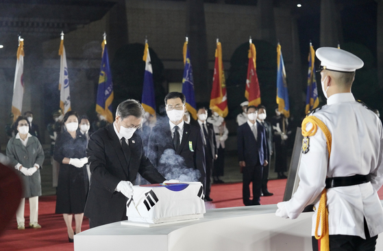 President Moon Jae-in takes part in a repatriation ceremony held at the Seoul Air Base Thursday night after the United States handed over the remains of 68 South Korean soldiers killed in the Korean War the previous day in Honolulu. [YONHAP]