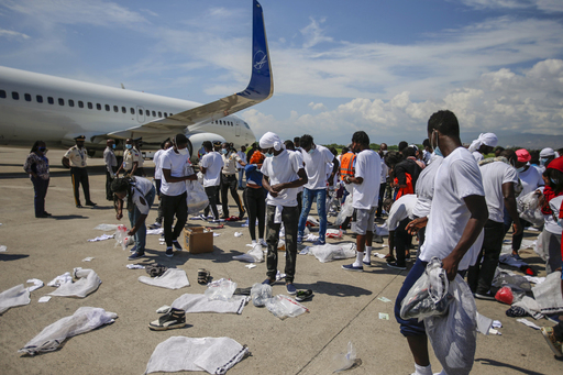 지난 21일(현지시간) 아이티 포르토프랭스 투생 루베르튀르 국제공항에서 미국에서 수송기를 타고 추방된 아이티 난민들이 소지품을 챙기고 있다. 포르토프랭스=AP연합뉴스