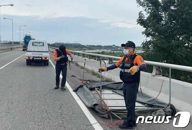 나주소방서 119생활안전순찰대가 지석대교 도로 위에 방치된 철제 구조물을 제거하고 있다. © News1