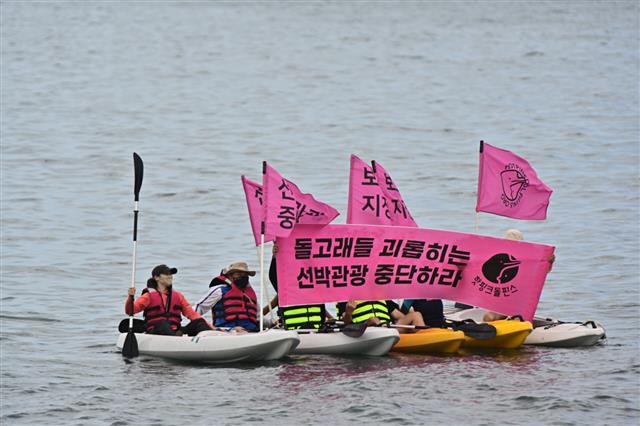 핫핑크돌핀스 회원들이 대정읍 해상에서 고래 관광선박 운항 중단을 요구하며 해상 퍼포먼스를 벌이고 있다.핫핑크돌핀스 제공