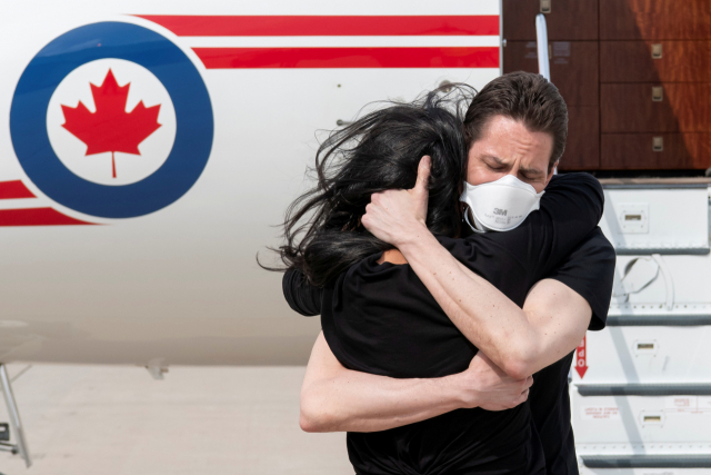 지난 2018년 중국 당국에 체포됐던 캐나다 전직 외교관 마이클 코브릭이 25일(현지 시간) 캐나다에 도착해 부인과 포옹하고 있다./로이터연합뉴스