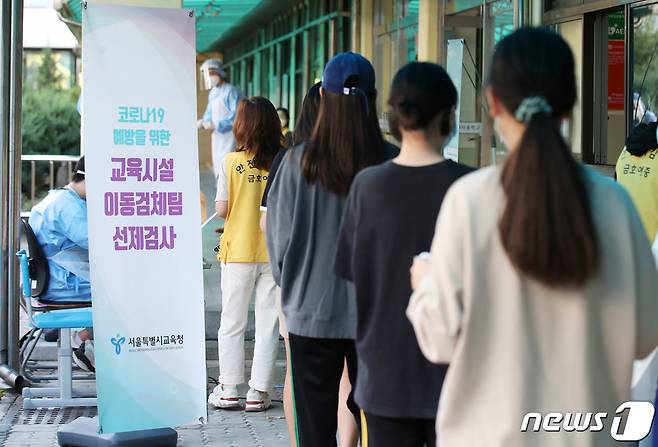 서울 중구 금호여중에 추석 연휴 이후 학생 확진자 확산을 막기 위해 마련된 이동식 PCR 검사소에서 학생과 교직원들이 검사를 받기 위해 줄지어 기다리고 있다.© News1 박지혜 기자