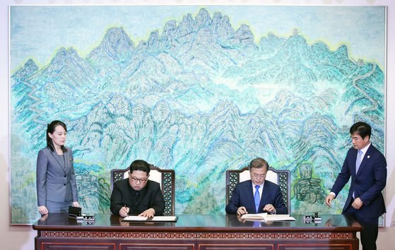 문재인 대통령(오른쪽 두 번째)과 김정은 북한 국무위원장(왼쪽 두 번째)이 2018년 4월 27일 남북 정상회담에서 한반도의 평화와 번영, 통일을 위한 판문점 선언문에 서명하고 있다. 왼쪽은 김 위원장 동생인 김여정 노동당 제1부부장, 오른쪽은 조한기 당시 청와대 의전비서관. 청와대사진기자단