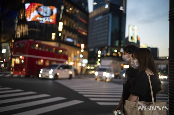 [도쿄=AP/뉴시스] 일본 수도 도쿄에서 23일 코로나19 예방을 위해 마스크를 착용한 시민들이 긴자 쇼핑가를 찾아 횡단보도를 건너려고 신호를 기다리고 있다. 2021.09.26