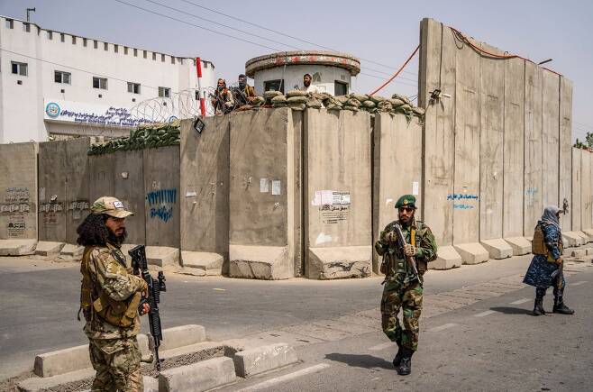 지난 11일 탈레반 정부를 지지하는 여성들의 행진이 진행되는 동안 탈레반 전사들이 카불대 주변을 순찰하고 있다./AP연합뉴스