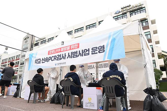 28일 서울 종로구 동성고등학교에서 학생들이 등교하며 코로나19 신속 자가분자진단 유전자증폭(신속 PCR) 검사를 받고 있다.