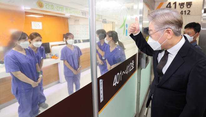 더불어민주당 대선 주자인 이재명 경기지사가 28일 인천의료원을 방문해 코로나19 음압병실 의료진을 향해 엄지손가락을 들어 보이고 있다.  사진공동취재단