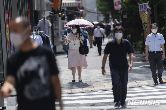 [도쿄=AP/뉴시스] 26일 일본 도쿄에서 코로나19 예방을 위해 마스크를 쓴 시민들이 횡단보도를 건너고 있다. 2021.08.26