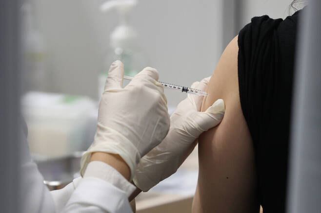 28일 오전 서울 마포구민체육센터에 마련된 코로나19 예방접종센터에서 한 시민이 백신 접종을 하고 있다. 연합뉴스