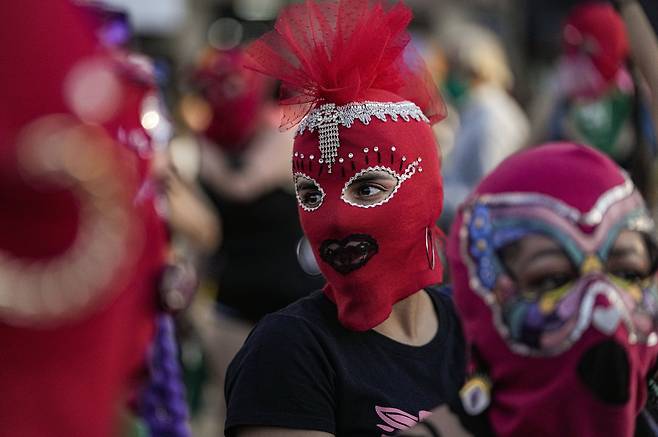 칠레 여성들이 28일 산티아고에서 복면을 쓰고 낙태 합법화 시위에 참가하고 있다. AP=연합뉴스