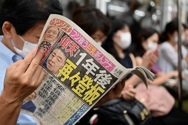 일본 도쿄 지하철에서 한 시민이 아베 신조 전 일본 총리 후임으로 스가가 낙점됐다는 내용의 신문을 읽고 있다./사진=AFP