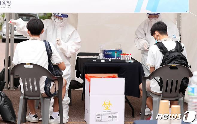 등교하며 코로나19 '신속 자가분자진단 유전자증폭(신속 PCR)' 검사를 받는 서울의 한 고등학교 학생. /뉴스1 © News1 사진공동취재단