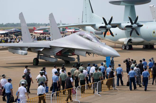28일 중국 광둥성 주하이에서 열린 13회 주하이 에어쇼에 중국 최신 군용기들 전시돼 있다. 관람객들이 전자전 장비를 탑재한 젠(J)-16D 앞을 지나고 있다./AP 연합뉴스
