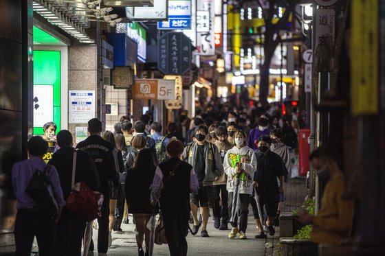 코로나19 긴급사태 해제 첫날인 1일 저녁, 마스크를 쓴 시민들이 일본 도쿄 시부야 상점가를 지나고 있다. [AP=연합뉴스]