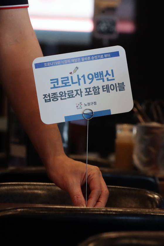 지난 3일 서울 노원구 한 식당에 ‘신종 코로나바이러스 감염증(코로나19) 백신 접종 완료자 포함 테이블’ 안내판이 설치돼 있다. 뉴스1
