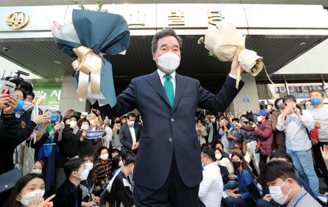 이낙연 전 더불어민주당 대표가 14일 오후 서울 여의도 대산빌딩에서 열린 필연캠프 해단식을 마친 뒤, 꽃다발을 들고 지지자들을 향해 손을 들고 있다. 뉴시스