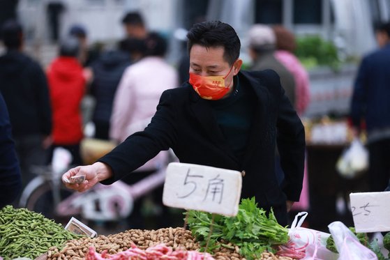 지난 14일 중국 랴오닝성 선양의 한 시장에서 시민이 채소를 사고 있다. [AFP=연합뉴스]