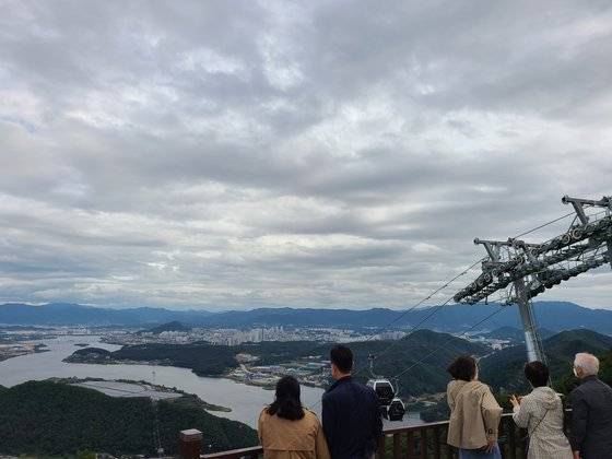 지난 12일 오전 강원 춘천시 서면 삼악산 호수 케이블카 상부 정차장을 찾은 관광객들이 춘천의 전경을 감상하는 모습. 박진호 기자