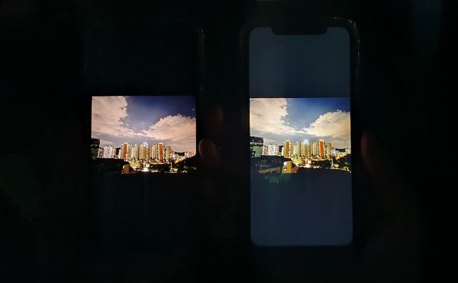 애플 스마트폰 ‘아이폰13’(왼쪽)과 ‘아이폰11’. 어두운 곳에서 OLED 디스플레이가 탑재된 아이폰13이 LCD가 탑재된 아이폰11보다 검은 화면을 더 잘 구현해 내는 모습을 확인할 수 있다.ⓒ데일리안 김은경 기자