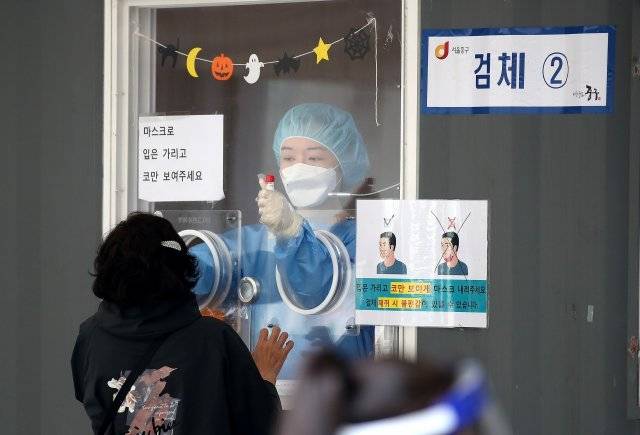 15일 서울 중구 서울역광장에 마련된 신종 코로나바이러스 감염증(코로나19) 선별진료소에서 의료진이 시민의 검체를 채취하고 있다. 2021.10.15. 뉴스1