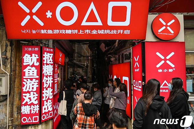 12일 중국 상하이에서 넷플릭스 드라마 ‘오징어 게임’을 테마로 한 달고나 가게에 손님들이 줄을 서서 기다리고 있다. © AFP=뉴스1 © News1 우동명 기자