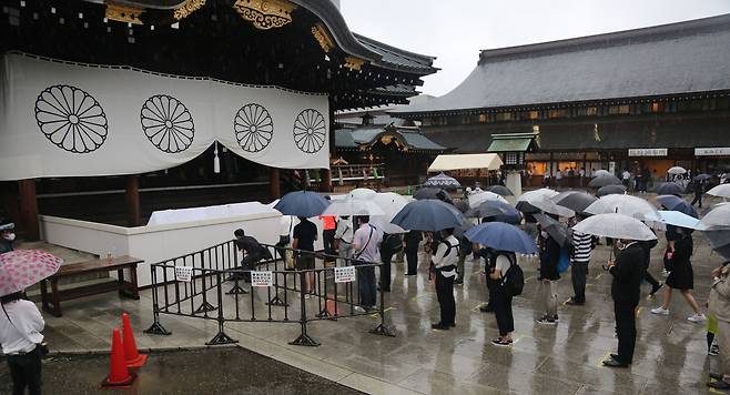 지난 8월 15일 일본 도쿄도(東京都) 지요다(千代田)구 소재 야스쿠니신사(靖國神社)에 비가 내리는 가운데 방문자들이 참배하기 위해 차례를 기다리고 있다. /연합뉴스