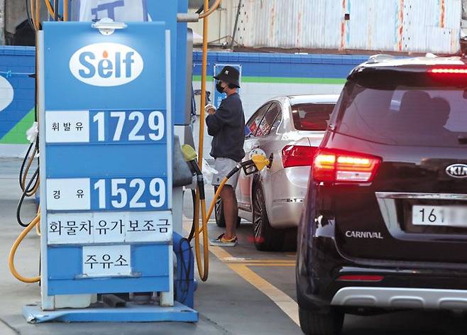 "기름 넣기가 무섭다" - 17일 오후 서울 시내 한 셀프 주유소에서 운전자들이 차량에 기름을 넣고 있다. 국내 휘발유 가격은 4주 연속 올라 지난 15일 1709.2원을 기록했다. 국내 휘발유 판매가가 1700원을 넘은 것은 2014년 12월 이후 7년 만이다. /장련성 기자