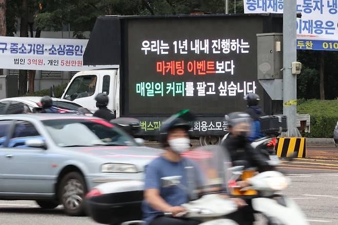A truck that reads, “We want to sell coffee, not engage in marketing and promotions,” drives through the streets of Seoul on Oct. 7, after a promotional event drew long lines of customers at Starbucks stores. (Yonhap)
