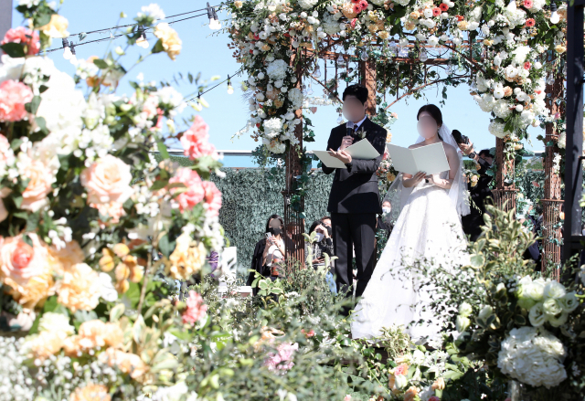 정부가 방역수칙을 완화하며 ‘위드 코로나’ 준비에 본격 시동을 건 가운데 17일 서울의 한 결혼식장에서 신혼부부가 예식을 치르고 있다./권욱 기자