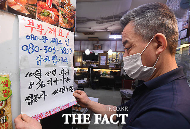 서울 종로구 한 식당에서 주인이 안내문을 수정하고 있다.