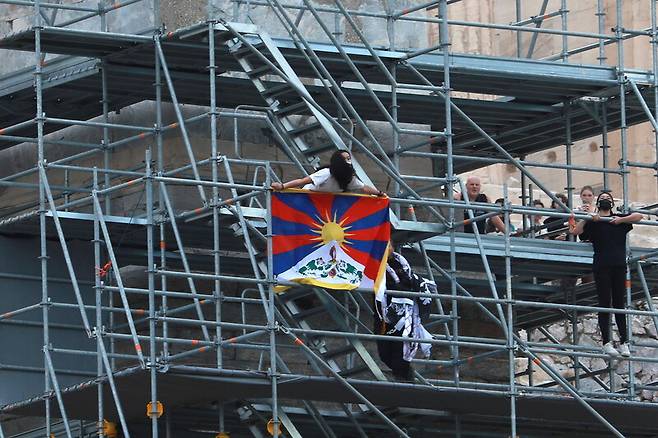 베이징겨울올림픽에 반대하는 활동가들이 17일(현지시각) 그리스 아테네 아크로폴리스에서 티베트 국기를 펼치고 시위를 벌이고 있다. 아테네/로이터 연합뉴스