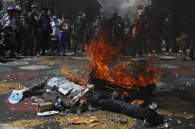 시위대가 나이브 부켈레 대통령의 인형을 불태우고 있다. AP=연합뉴스