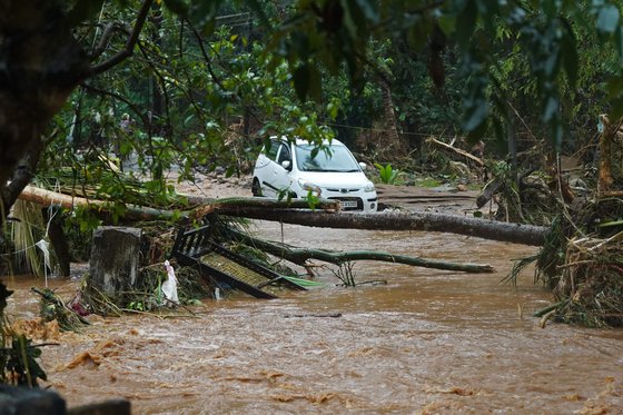 16일 인도 케랄라주 토두푸자에서 홍수로 범람한 도로에 자동차가 갇혀 있다. 연합뉴스