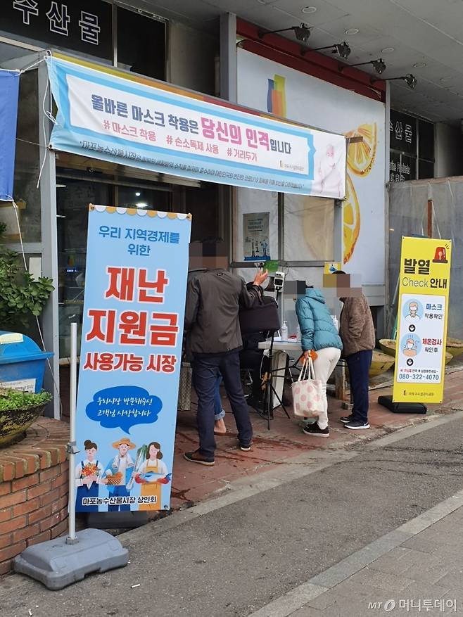 18일 오전 9시30분쯤 서울 마포구 성산동 마포농수산물시장 출입구에서 시민들이 발열체크와 방문자 등록을 하고 있다. /사진=홍재영 기자