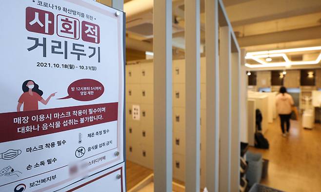 현행 사회적 거리두기 단계가 2주 연장된 18일 서울 시내 스터디카페에 운영시간 변경 안내문이 붙어있다. 뉴시스