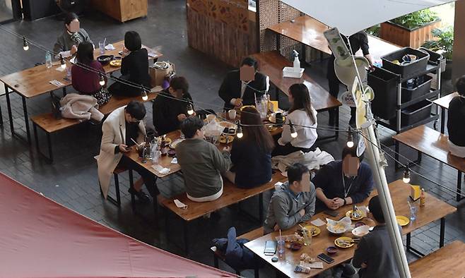 새 거리두기 조정안이 시행된 18일 서울 시내 한 식당가에서 시민들이 식사를 하고 있다. 정부는 단계적 일상회복 전환 준비단계로 이날부터 수도권에서 백신 미접종자 4명을 포함해 최대 8명까지 모임을 할 수 있도록 했다. 하상윤 기자