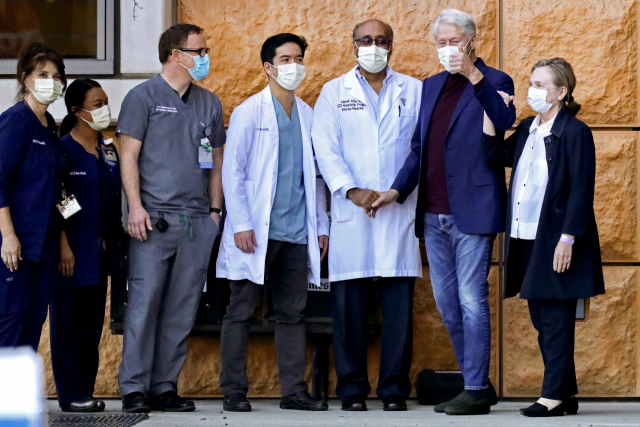 빌 클린턴(왼쪽 여섯 번째) 전 미국 대통령이 힐러리(〃 일곱 번째) 여사와 함께 17일(현지 시간) 캘리포니아주 어바인 대학 병원을 나서며 엄지를 치켜올리고 있다. /연합뉴스
