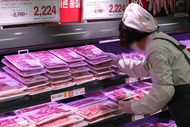글로벌 물류대란 여파로 소고기와 돼지고기 가격이 치솟아 연일 역대 최고가를 기록하고 있다. 지난 18일 오후 서울 시내 한 대형마트 직원이 돼지고기와 소고기를 진열하고 있다. 뉴스1