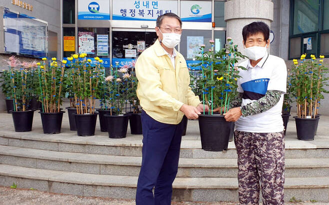 10여 년째 고창군 성내면사무소에 국화 화분을 기부해온 농부 김사배(64) 씨(오른쪽).
