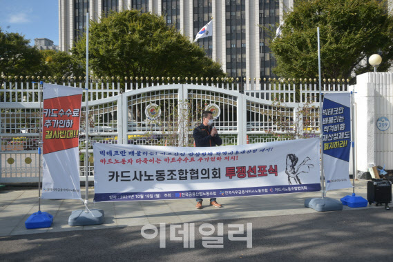 카드사노동조합협의회 관계자가 18일 서울 정부종합청사 앞에서 가맹점 수수료 인하 반대 집회를 열고 발언하고 있다. (카드사노동조합협의회 제공)