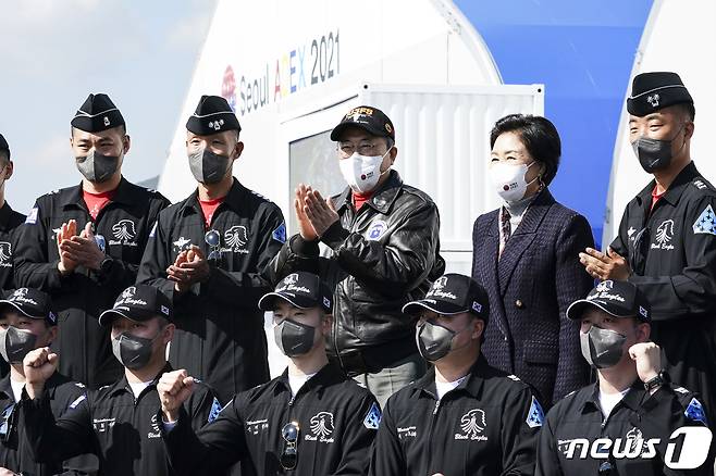 문재인 대통령과 김정숙 여사가 20일 경기도 성남시 서울공항에서 열린 2021 서울 국제 항공우주 및 방위산업 전시회(ADEX) 개막 기념행사에 참석해 시범비행을 마친 공군 특수비행팀 블랙이글스 대원들과 기념촬영을 하고 있다. 2021.10.20/뉴스1 © News1 이광호 기자